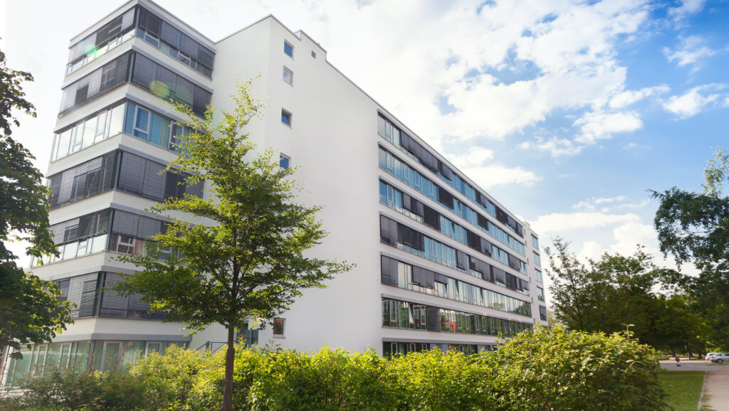 Grosser Wohnblock Mehrfamilienhaus hinter Parkanlage